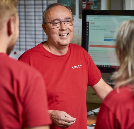 Usměvavý muž v červeném triku s logem Veit